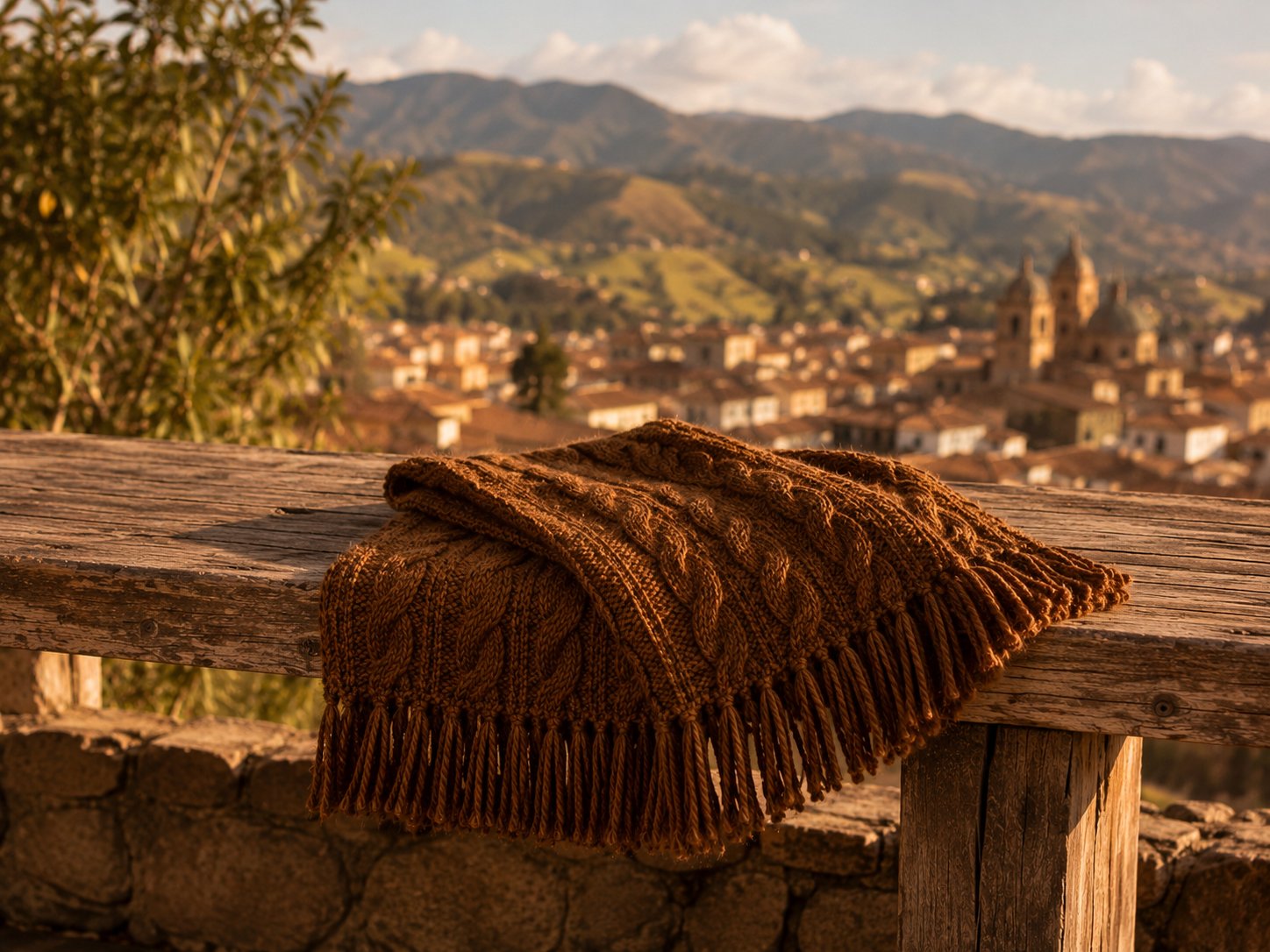 Handknitted brown alpaca scarf resting on a wooden rail overlooking Cajamarca, Peru